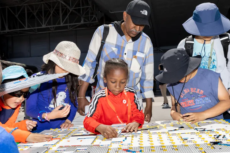 A family engaging in a fun activity on Pier 86 during Fleet Week.